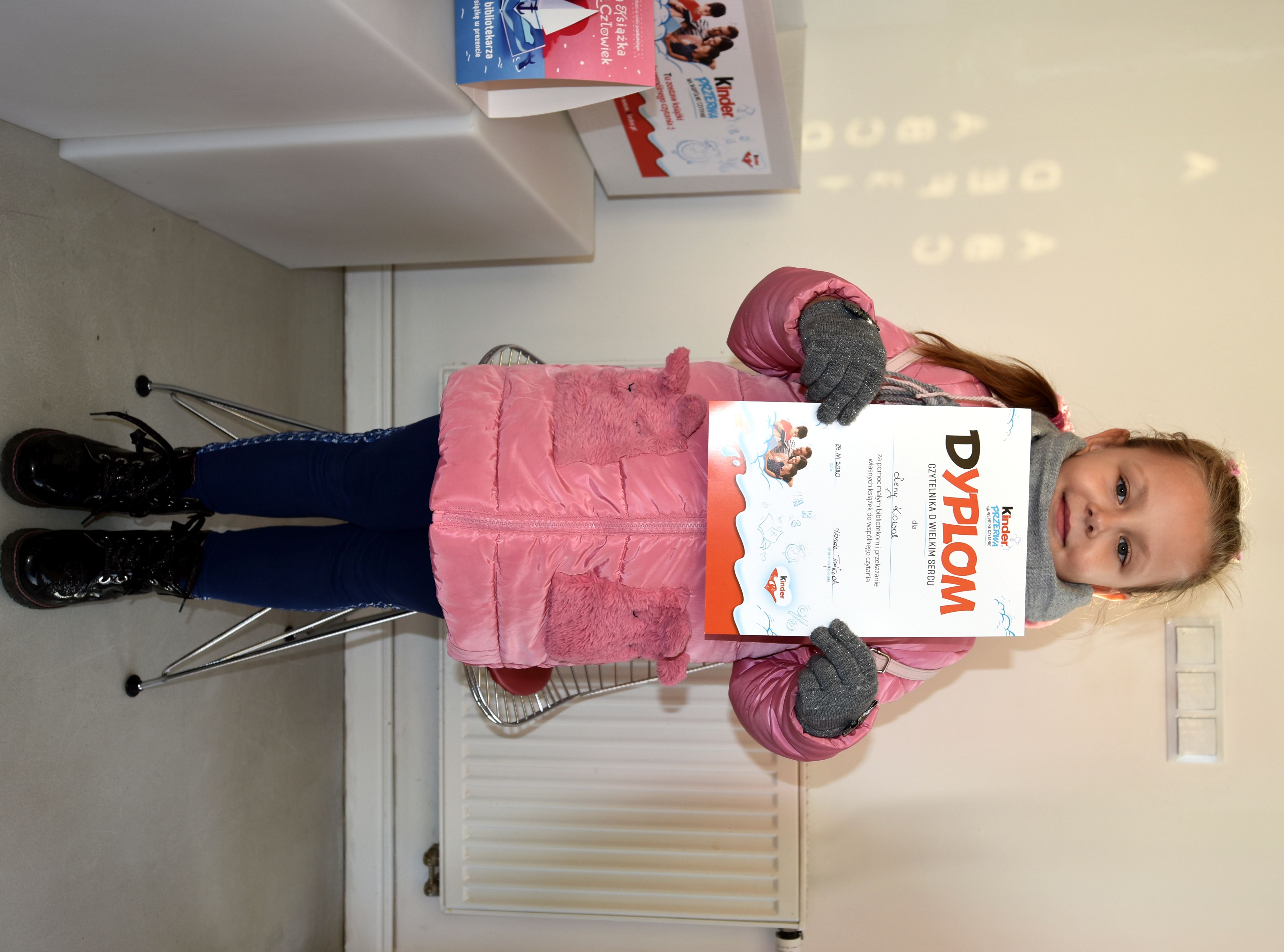 Lena z dyplomem Czytelnika o Wielkim Sercu, który dostała  za przekazanie książek w ramach akcji Kinder "Podziel się książką" 